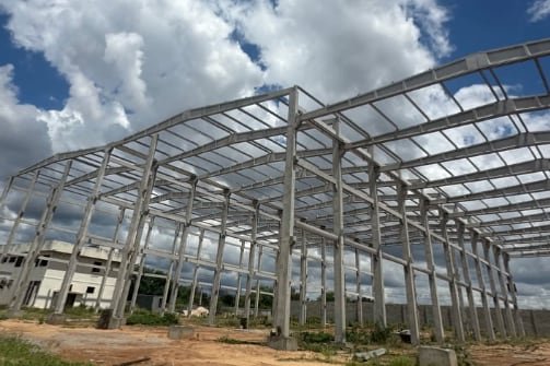 Galpão industrial de múltiplos vãos com pilares e vigas de concreto já montados